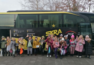 Grupa dzieci na tle autobusu Skry
