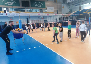 Grupa dzieci z zawodnikiem Skry trenuje grę w siatkę