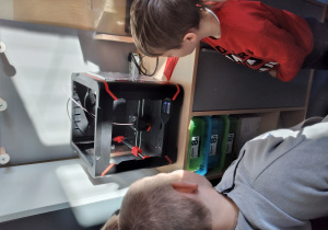 Dzieci patrzą na pracę drukarki 3D