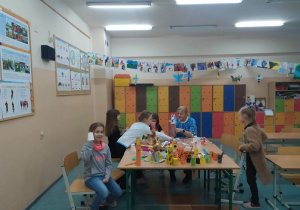 Dzieci przy stoliku wykonujące prace plastyczno-techniczne