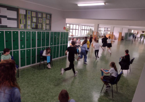 Dzieci biegnące po korytarzu szkolnym na tle szafek
