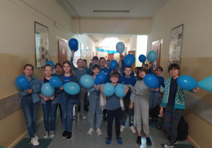 Dzieci z niebieskimi balonami w niebieskich strojach