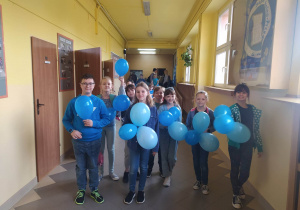 Dzieci z niebieskimi balonami w niebieskich strojach