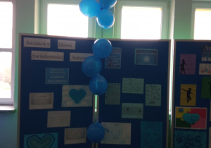 Wystawa z napisem Światowy Dzień Świadomości Autyzmu i niebieskie balony
