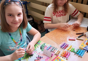 Dzieci przy stoliku wykonują prace plastyczne z plasteliny