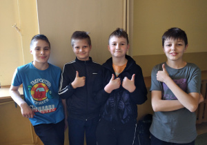 4 chłopców stoi z założonymi rękami.