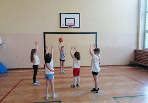 Dzieci na sali gimnastycznej z piłką