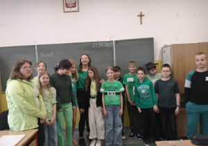 Duża grupa dzieci ubrana na zielono pozuje do zdjęcia
