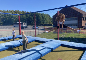 Dzieci skaczą na trampolinach