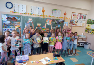 Dzieci trzymają książki wysoko w dłoniach