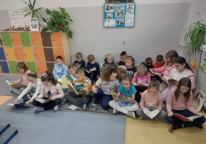 Dzieci siedzące na dywanie czytają książki