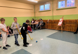 dzieci grają kijem do hokeja