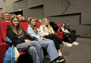 Dziewczyny siedzą na fotelach w kinie