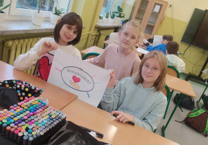 Dziewczynki pokazują napis wolontariat