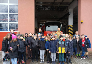 Dzieci stoją przed budynkiem Straży Pożarnej