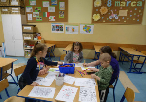 Dzieci przy stoliku malują obrazki