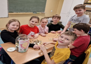Dzieci przy stoliku liczą drobne monety