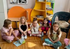 Dzieci z książkami siedzą na podłodze