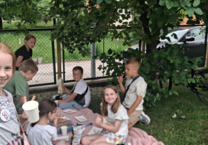Uśmiechnięte dziewczynki machają do zdjęcia