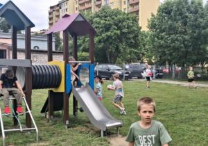 Dzieci bawią się na drewnianej zjeżdżalni