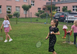 Dziewczynki grają w badmintona na trawie