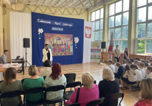 Pani mówi przez mikrofon na uroczystości