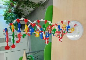 Na ławce stoi model łańcucha DNA