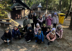 Uśmiechnięta grupa dzieci z kobietą pozują do zdjęcia