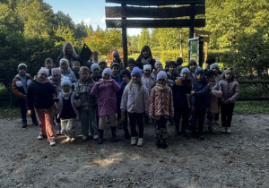 Uśmiechnięta grupa dzieci z 2 paniami pozują do zdjęcia