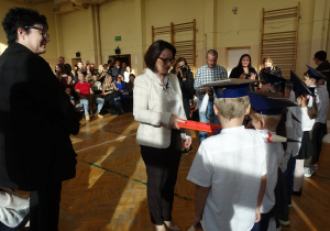 Kobieta z rekwizytem ołówka dzieci w biretach