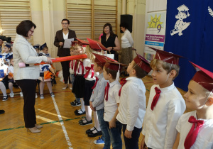 Kobieta z rekwizytem ołówka dzieci w biretach