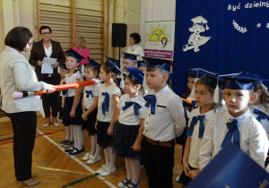 Kobieta z rekwizytem ołówka dzieci w biretach