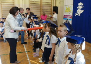 Kobieta z rekwizytem ołówka dzieci w biretach