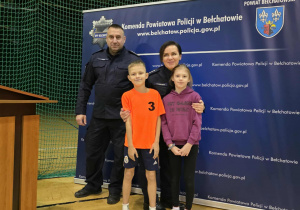 Dzieci w strojach sportowych stoją obok policjantów