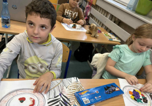 Dzieci wykonują kolorową pracę plastyczną