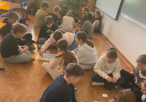 Cała klasa gra w gry planszowe na podłodze