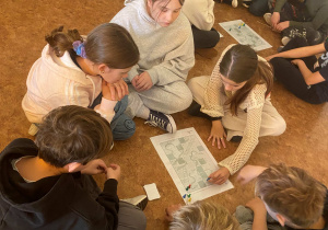 Uczniowie grają na podłodze w gry planszowe