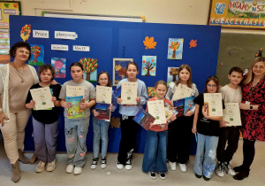 Kobiety i uśmiechnięte dzieci z dyplomami