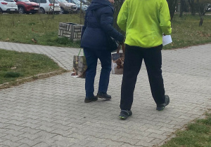 Uczeń wręcza ulotkę kobiecie