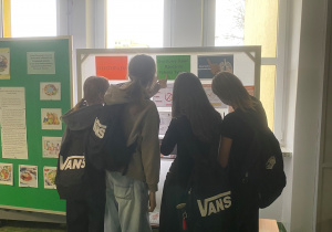 Uczennice czytają gazetkę informacyjną