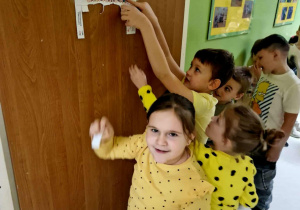 Uśmiechnięta dziewczynka stoi przy drzwiach