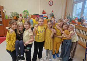 Grupa radosnych dzieci w żółtych bluzkach
