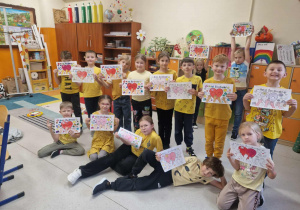 Grupa radosnych dzieci z sercami na kartkach