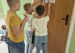 Uśmiechnięci chłopcy stoją przy drzwiach