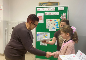 Uczennica otrzymuje dyplom i upominek od Pani wicedyrektor. (2)