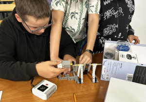 Chłopcy składają elementy robota