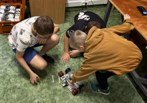 Chłopcy składają elementy jeżdżącego robota