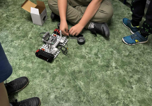 Chłopcy składają elementy jeżdżącego robota