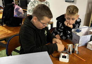 Chłopcy składają elementy robota- huśtawki