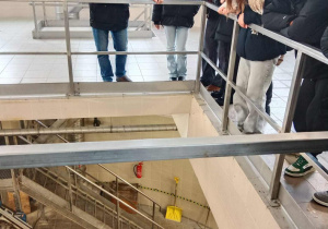 Młodzież stojąca wokół otworu przy barierce